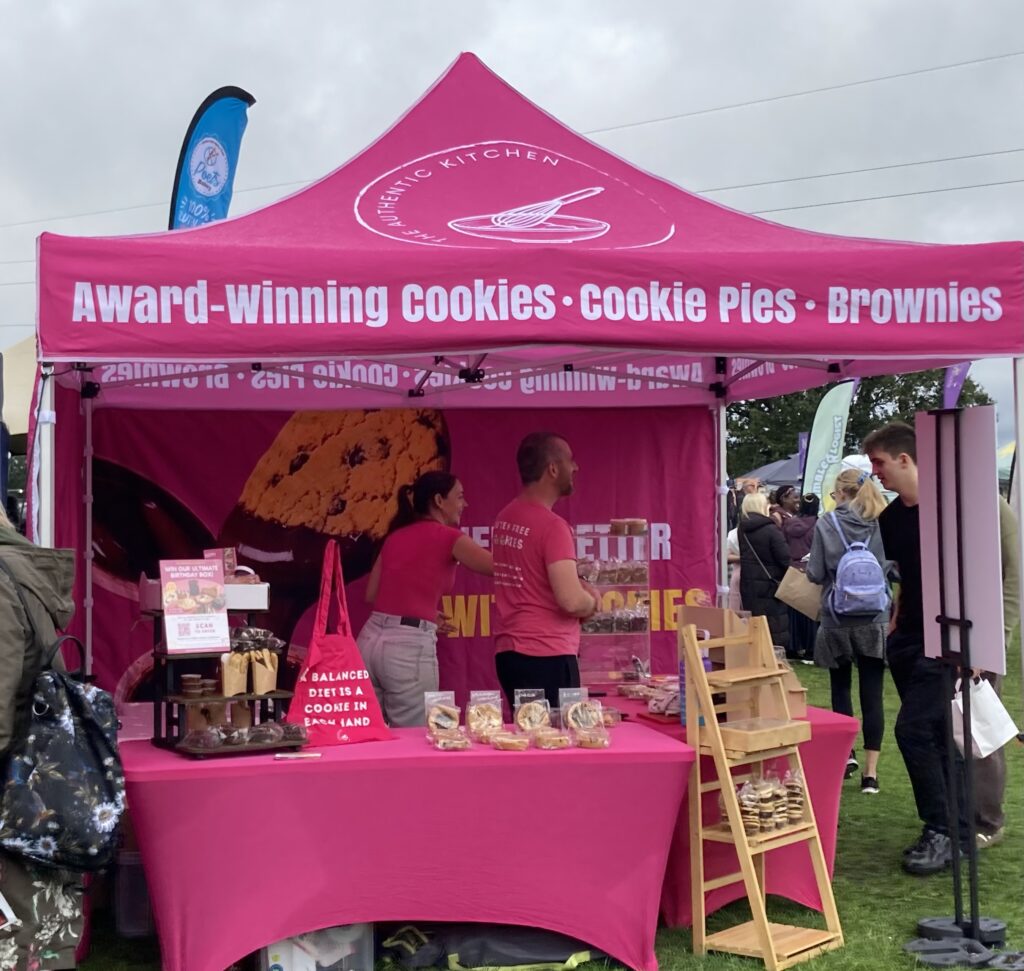 The Authentic Kitchen's pink gazebo stall selling gluten-free cookies at the Free From Festival, Birmingham